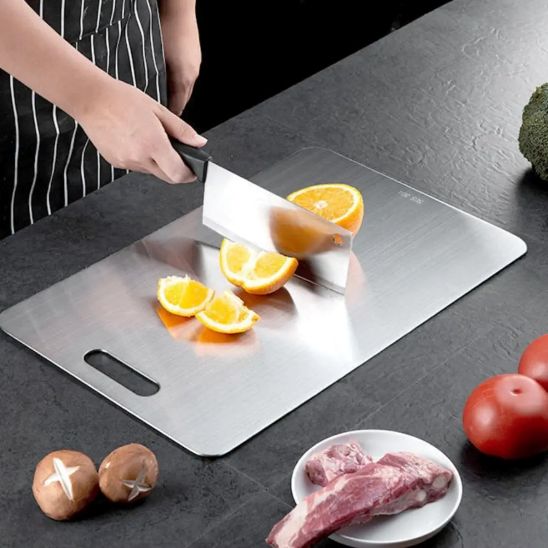 nana decouper orange sur planche a decouper inox