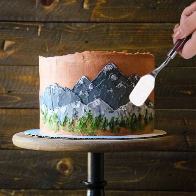 mama dessine sur gâteau avec spatule patisserie