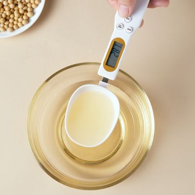 maman mesure huile avec cuillere doseuse