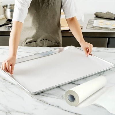 maman utilise papier cuisson pour couvrir plaque au four