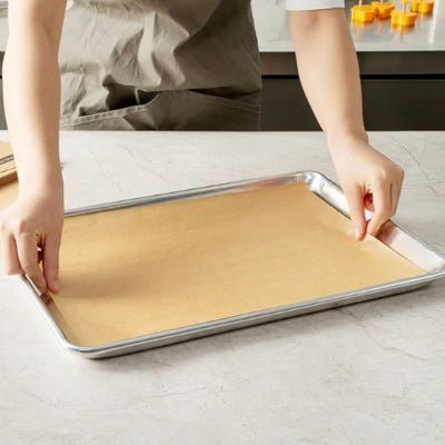 maman met papier cuisson sur une plaque