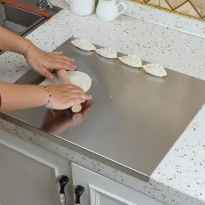 nana roule pate sur planche à découper en acier inoxydable