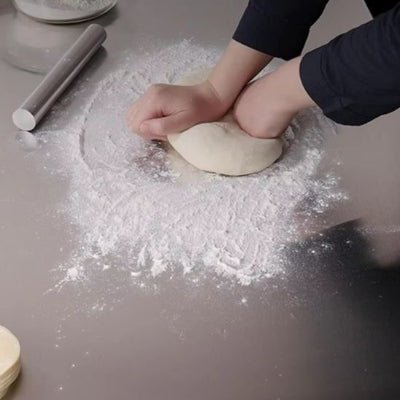 nana pétrie pate sur planche à découper en acier inoxydable