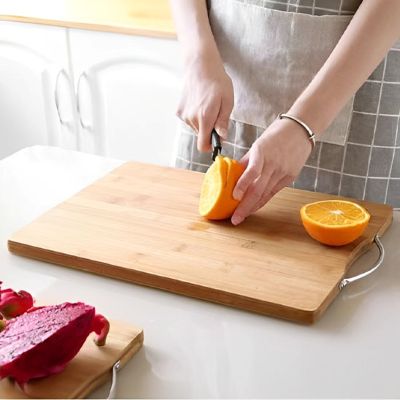 maman decoupe fruits sur planche a decouper bambou