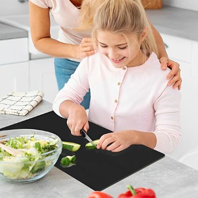 maman et fille decoupent legumes sur planche a decouper noir