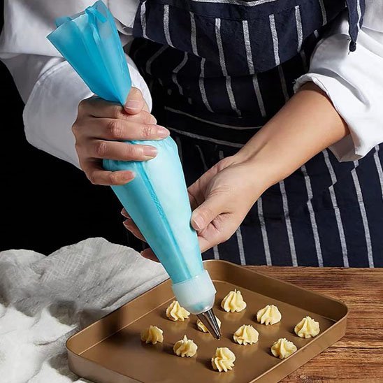 maman utilise poche a douille pour creer petits gateaux