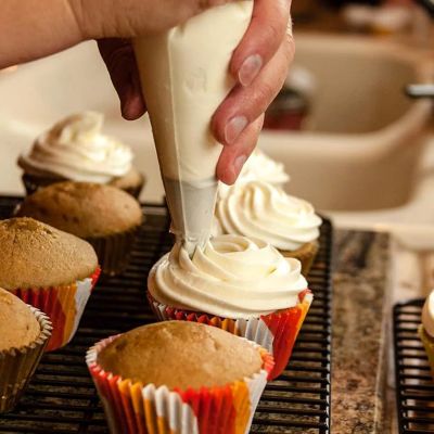 mama décore cupcakes avec poche à douille pâtisserie