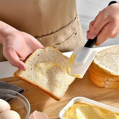 nana met beurre sur pain avec spatule a patisserie