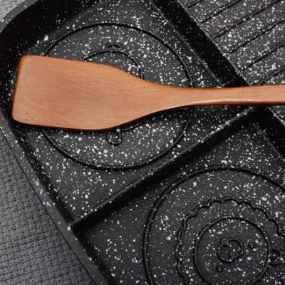 nana prend riz avec spatule en bois dans poele