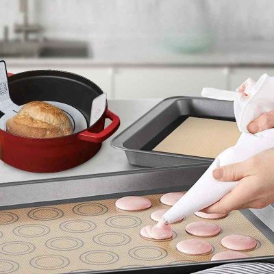 maman dispose macarons sur tapis cuisson