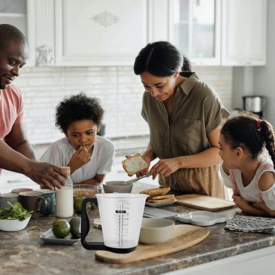 maman utilise tasse a mesurer numerique pour melanger pate crepe