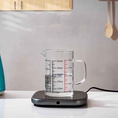 nana depose verre doseur en verre sur cuisiniere