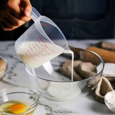 maman utilise verre doseur moyen pour lait